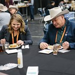 A woman and a man sitting at a table getting ready to eat a plate of beef